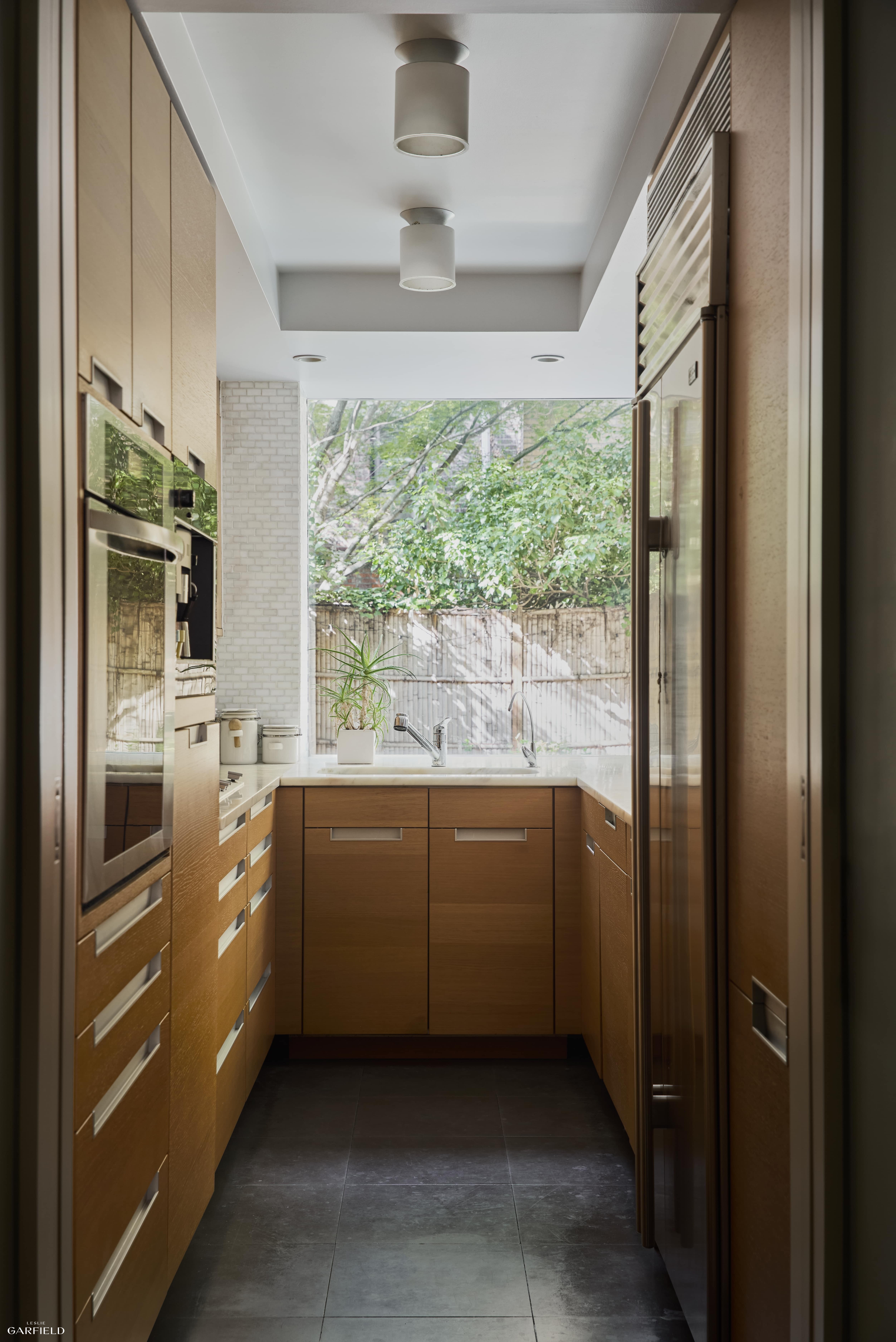315 West 84th Street Manhattan, NY 10024 - Photo 16 of 20 a kitchen with stainless steel appliances granite countertop a refrigerator a sink a stove and a refrigerator
