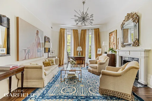 a living room with fireplace furniture and a large window