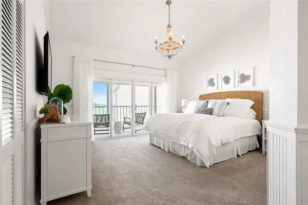 a spacious bedroom with a bed and a chandelier