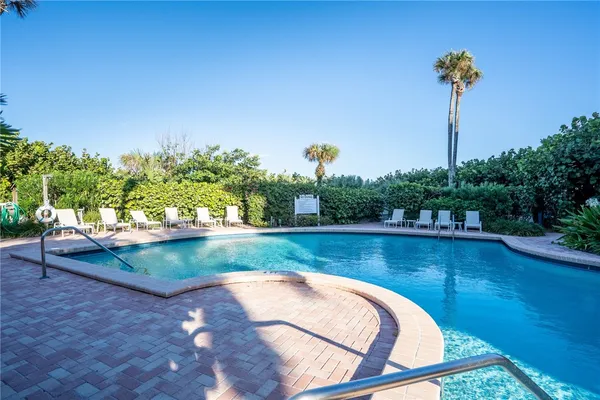 a view of a swimming pool with a yard and a wooden fence