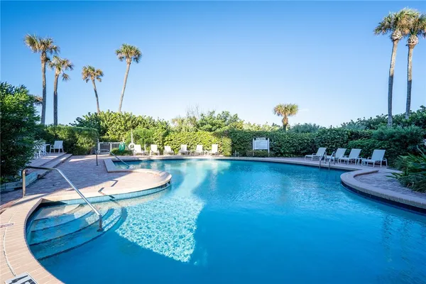 a view of a swimming pool with a yard and plants