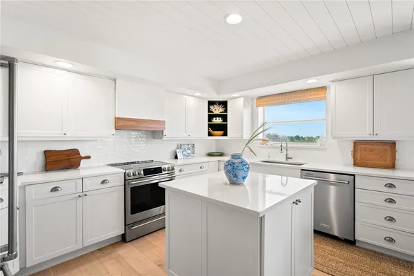 a kitchen with a sink a stove and cabinets