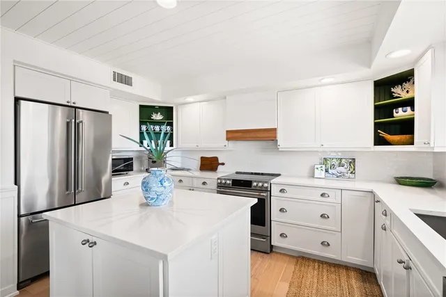 a kitchen with white cabinets and stainless steel appliances