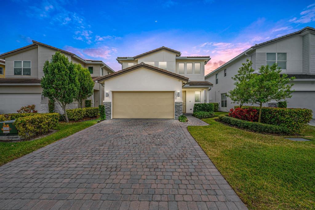 a front view of a house with a yard and garage