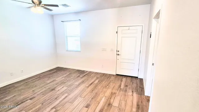 a view of a room with wooden floor and white walls