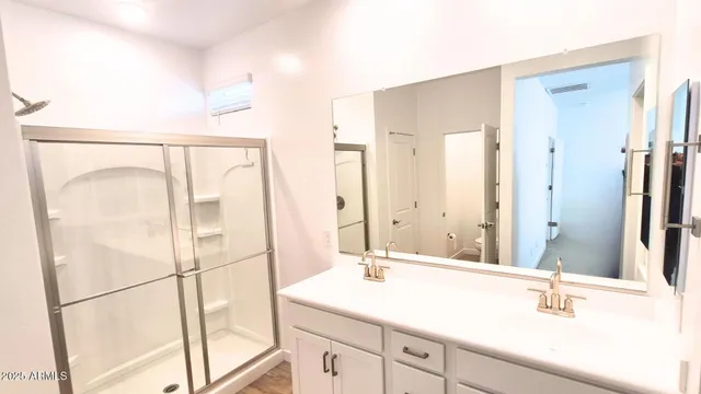 a bathroom with a shower sink and mirror