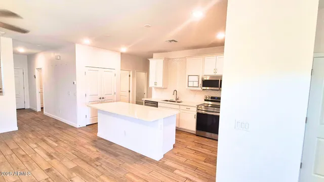 a large kitchen with a sink and a refrigerator