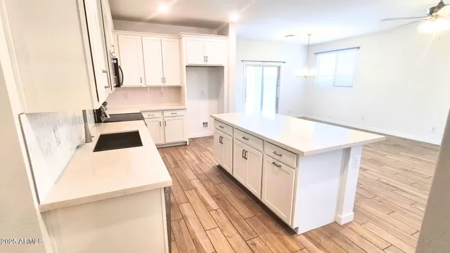 a kitchen with a sink a stove a refrigerator and white cabinets