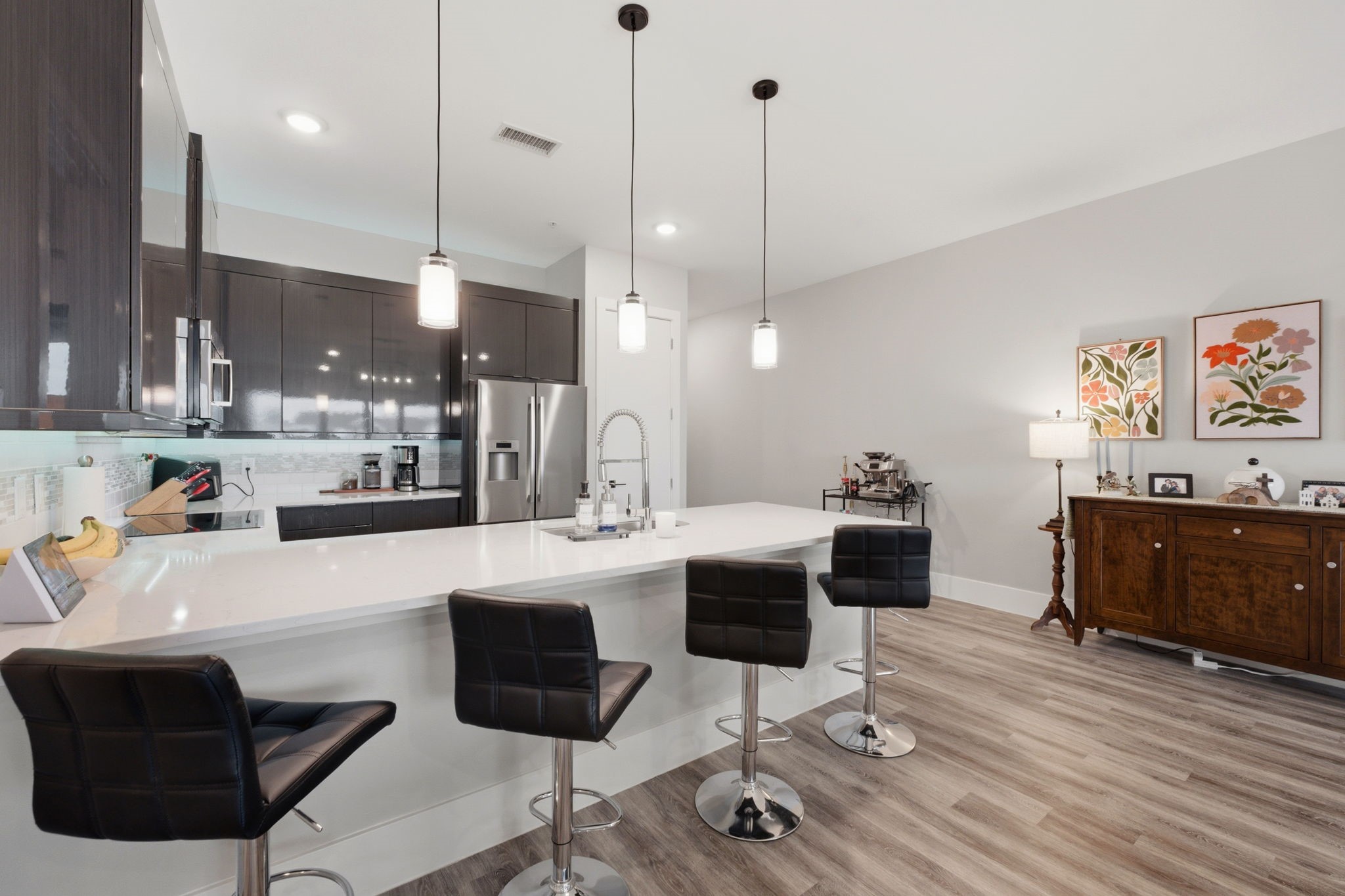 199 Waterpoint Court, Unit 202 Conroe, TX 77304 - Photo 11 of 41 a kitchen with kitchen island a dining table chairs sink and stove