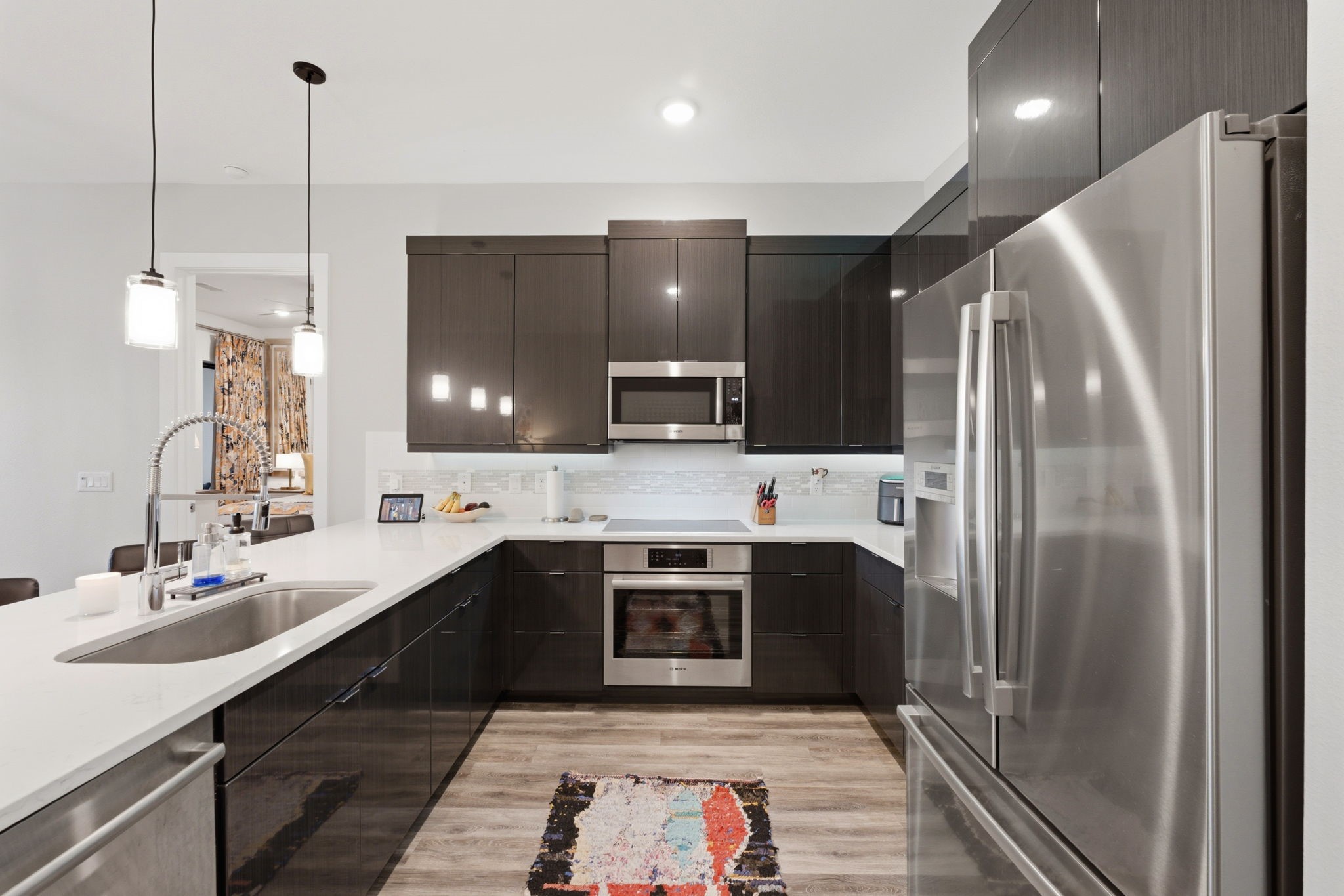 199 Waterpoint Court, Unit 202 Conroe, TX 77304 - Photo 13 of 41 a kitchen with stainless steel appliances a sink a stove a refrigerator and island
