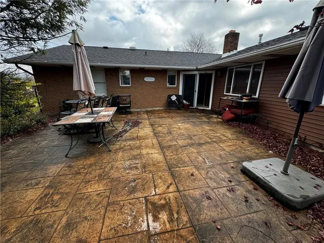 a view of a patio with table and chairs with wooden floor and fence