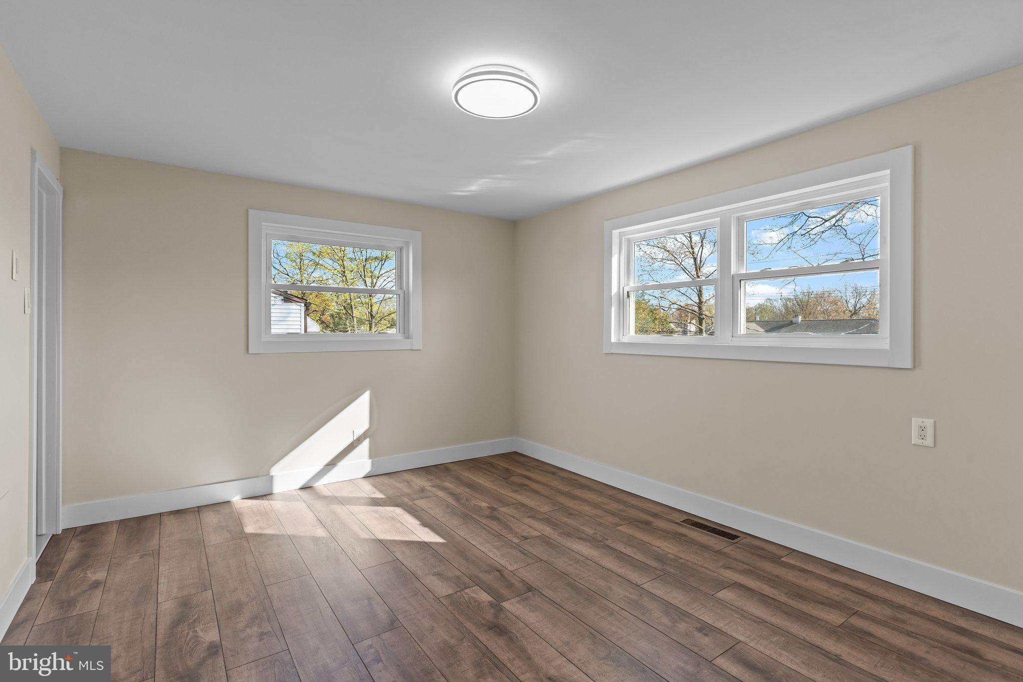 686 Spruce Road Warminster, PA 18974 - Photo 15 of 38 a view of an empty room with a window and wooden floor