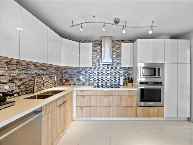 a kitchen with stainless steel appliances a sink a stove and cabinets