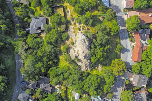 an aerial view of residential house with outdoor space and trees all around