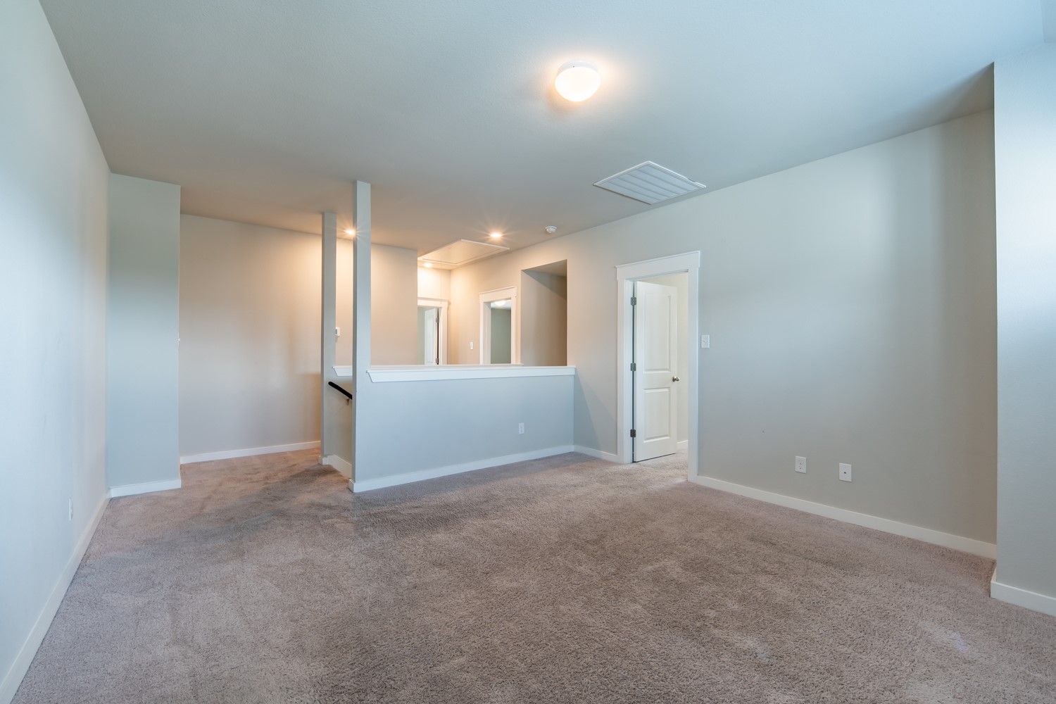 147 Waterside Road, Unit A Buda, TX 78610 - Photo 18 of 27 A spacious, naturally illuminated loft area offers versatile living space with plush carpeting and modern finishes.