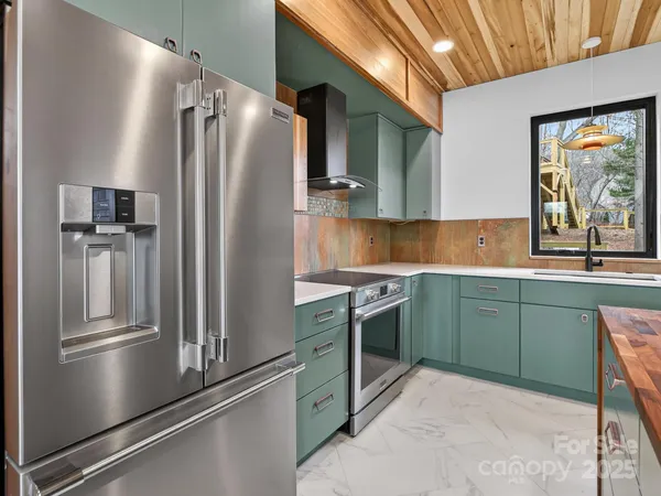 a kitchen with stainless steel appliances granite countertop a refrigerator and a sink