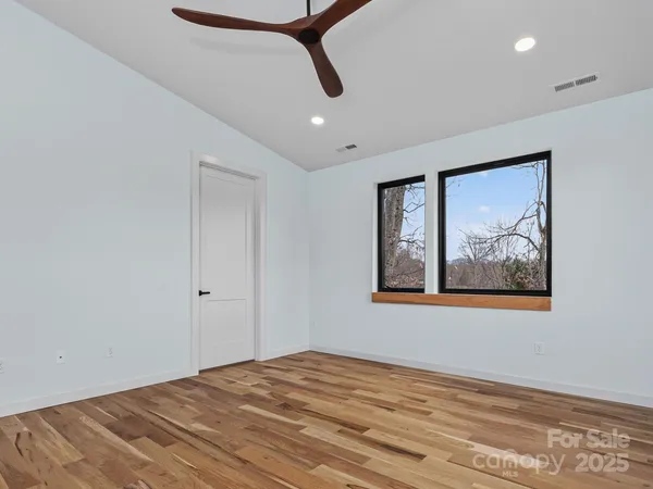 a view of a room with wooden floor and window