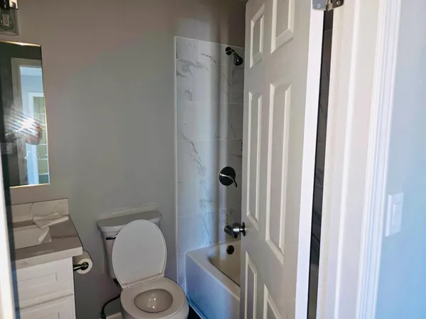 a bathroom with a sink a toilet a mirror and shower