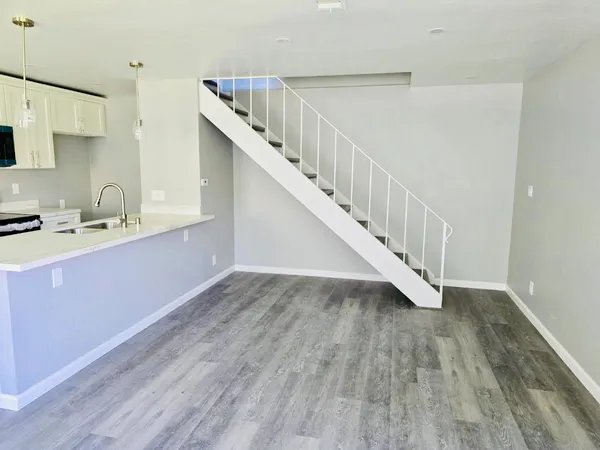 a view of a kitchen with wooden floor and electronic appliances