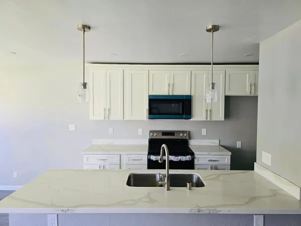 a kitchen with a sink a stove and cabinets