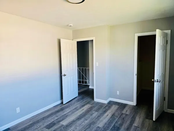 an empty room with wooden floor and closet