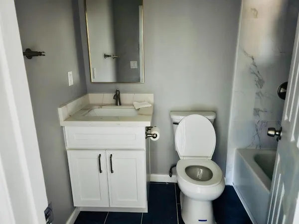 a bathroom with a toilet sink and mirror