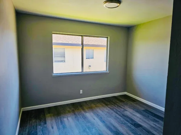a view of a room with wooden floor and a window