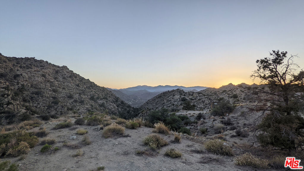 20 West Omega Trail Yucca Valley, CA 92286 - Photo 25 of 32 a view of a house with a mountain and mountains in the background
