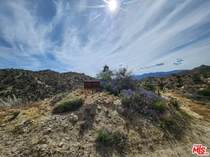 an aerial view of house with yard and mountain view in back