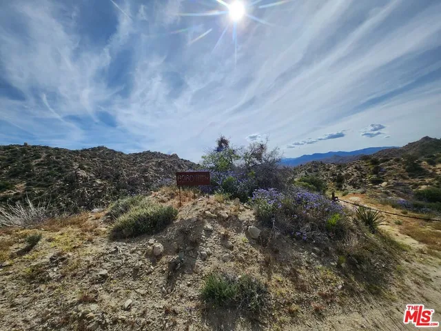 an aerial view of house with yard and mountain view in back