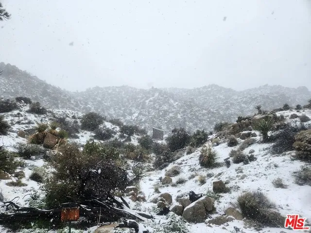 a view of a large building with mountains in the background
