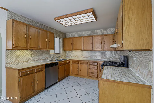 a kitchen with stainless steel appliances granite countertop a sink stove and cabinets