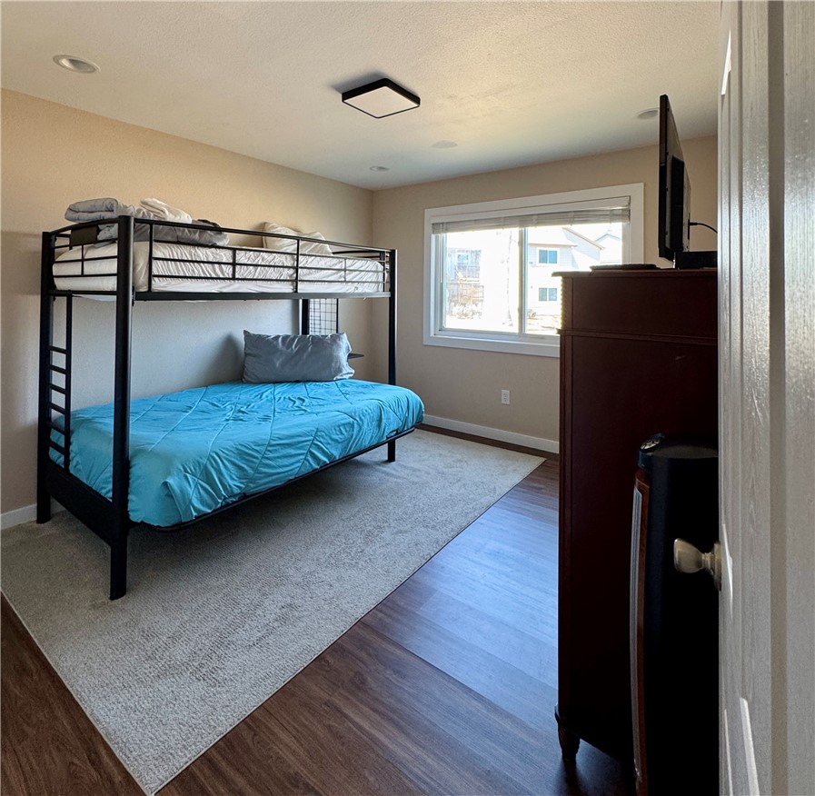 230 Cut-Off Road, Unit B107 Port Aransas, TX 78373 - Photo 8 of 25 a bedroom with a bed and wooden floor