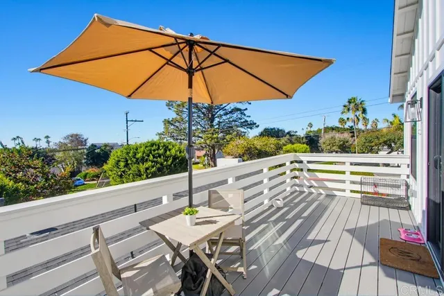 a view of balcony with furniture and umbrella