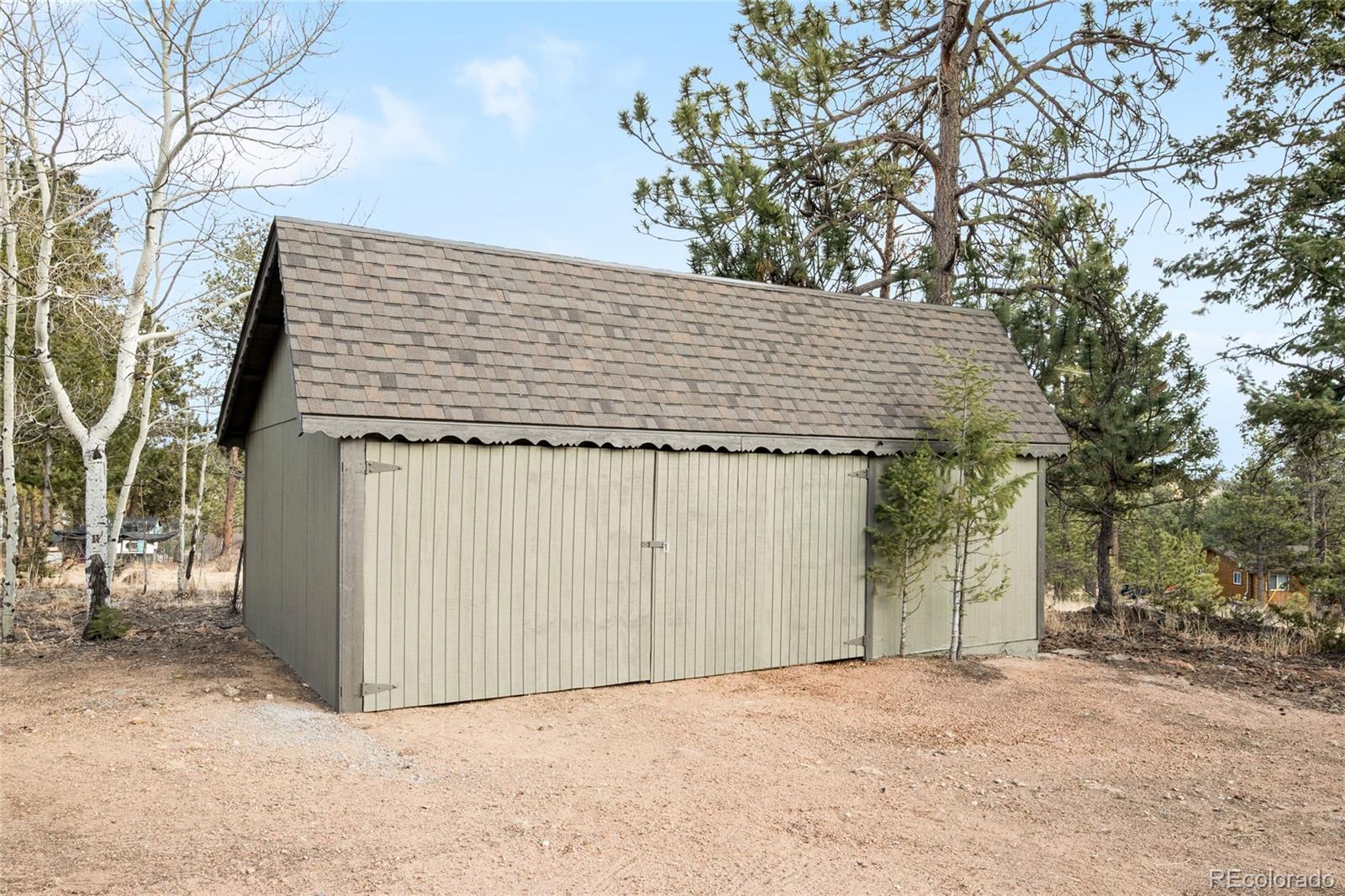 34657 Mohawk Trail Pine, CO 80470 - Photo 34 of 46 a front view of a house with a yard and garage