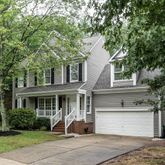 a front view of a house with a yard and potted plants