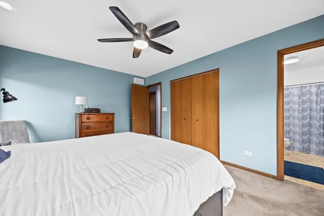 a bedroom with a large bed and a chandelier