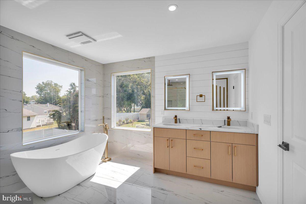 2504 Church Road Cinnaminson, NJ 08077 - Photo 32 of 79 a spacious bathroom with a double vanity sink a large mirror and a bathtub