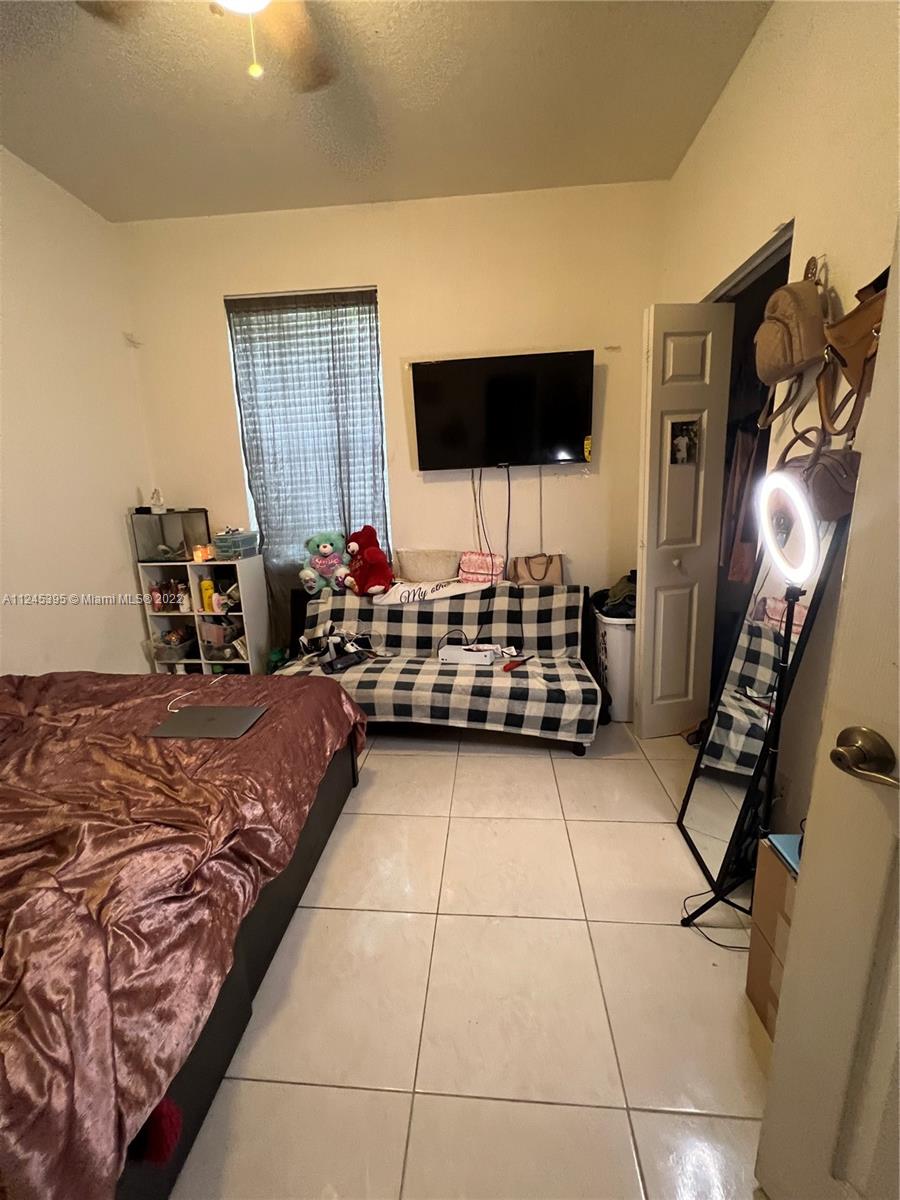 Hampton Hills Condominiums Tamarac, FL 33321 - Photo 11 of 24 a bedroom with furniture and flat screen tv