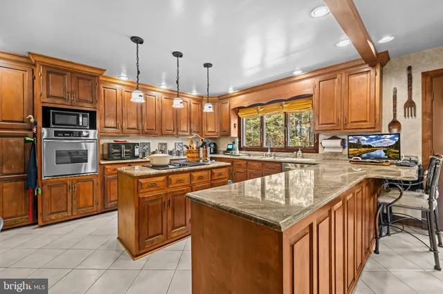 a kitchen with stainless steel appliances granite countertop a sink and a wooden floors