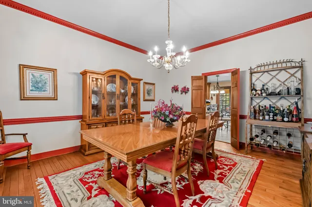 a view of a dining room with furniture a chandelier and wooden floor