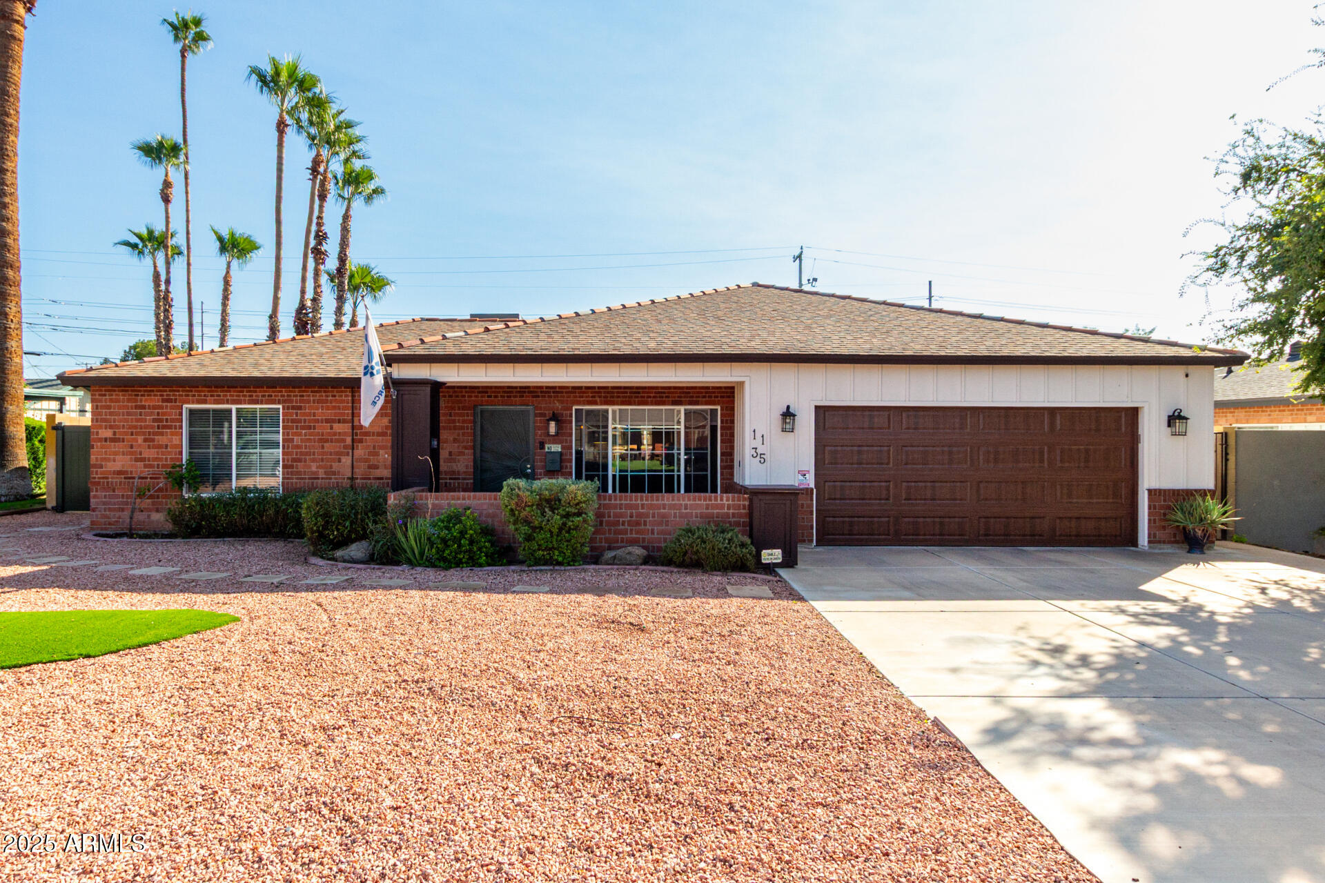 a front view of a house with a yard and potted plants