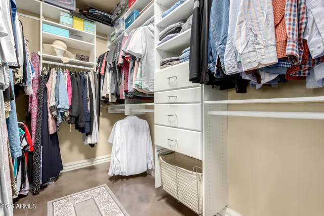 a view of walk in closet with clothes and shoes