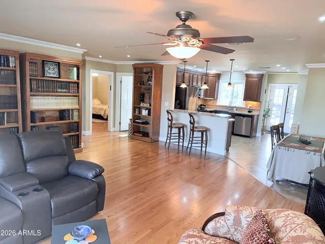 a living room with furniture kitchen view and a wooden floor