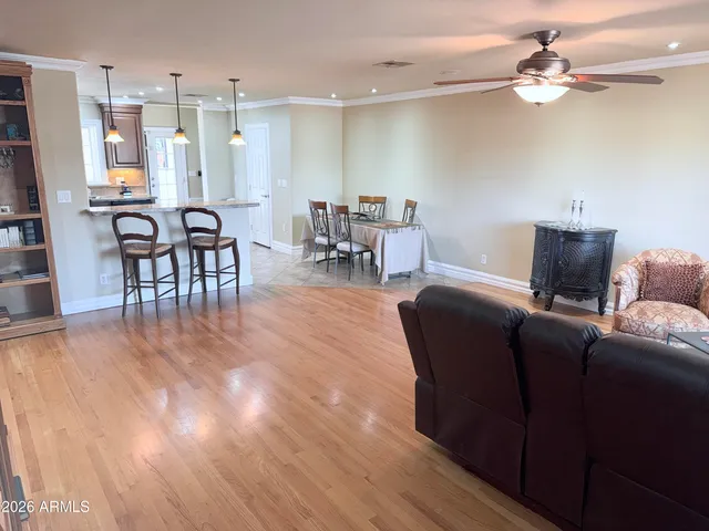 a living room with furniture a flat screen tv and kitchen view