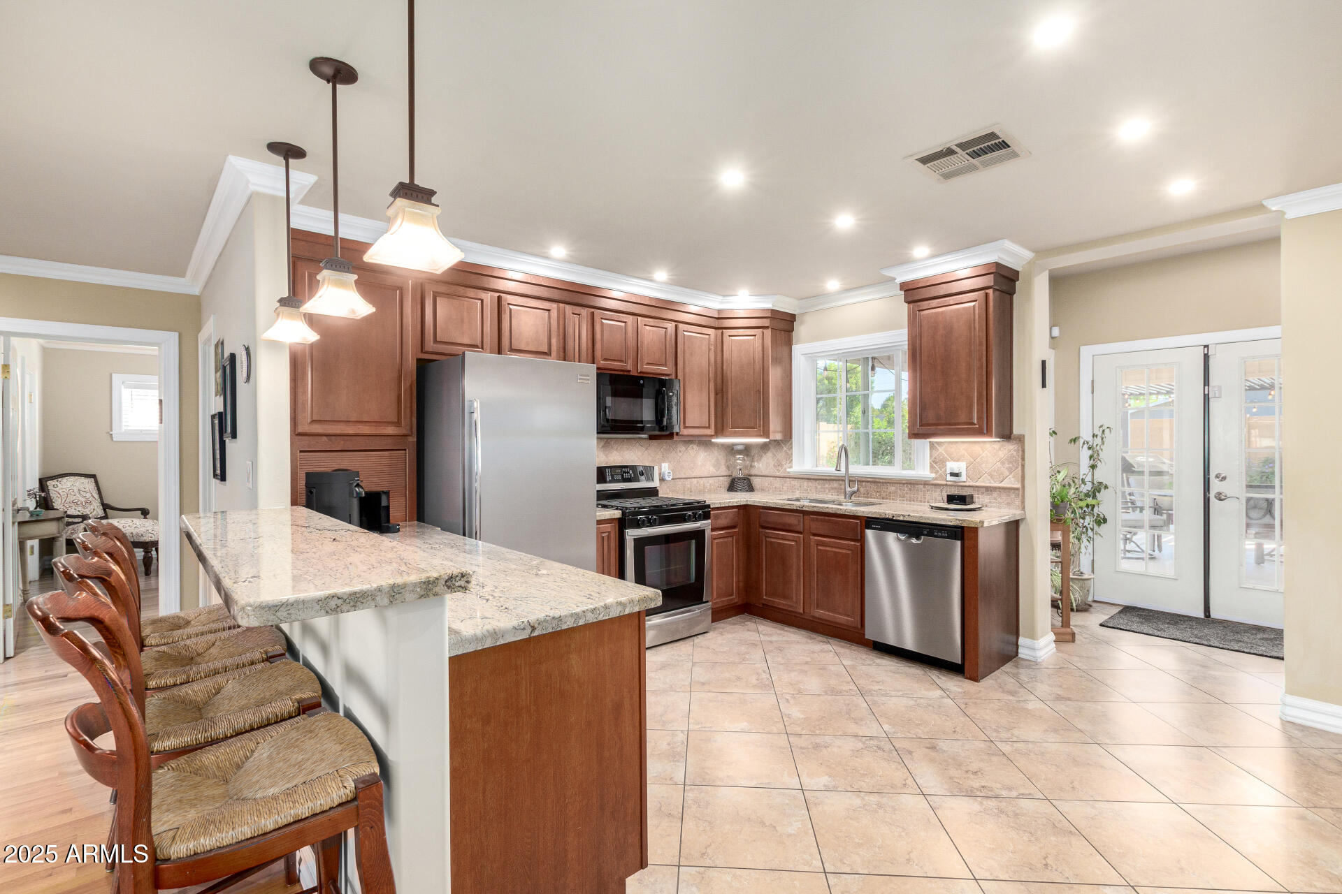 1135 East Lawrence Road Phoenix, AZ 85014 - Photo 6 of 18 a large kitchen with kitchen island a large counter top stainless steel appliances and cabinets
