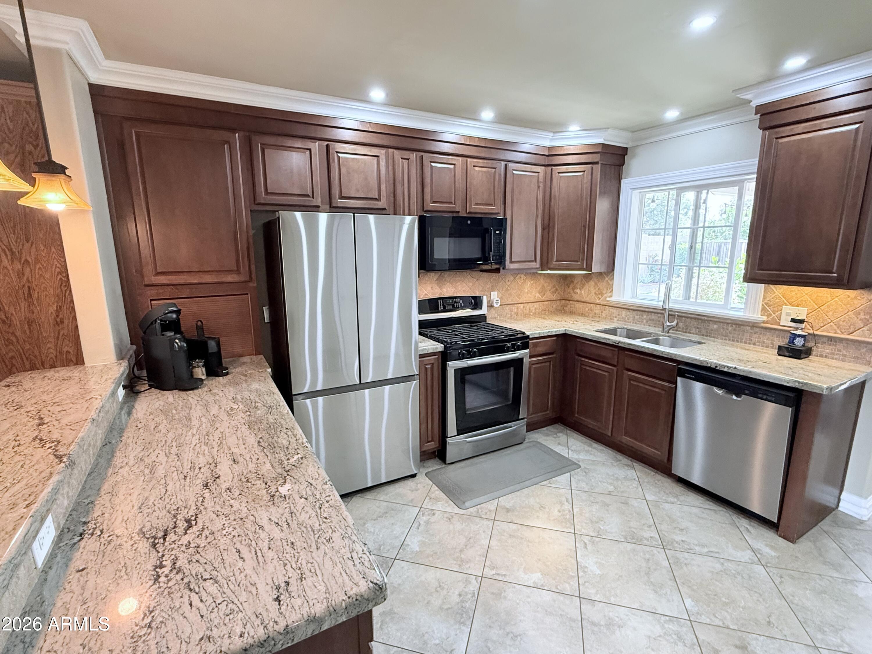 1135 East Lawrence Road Phoenix, AZ 85020 - Photo 6 of 23 a kitchen with stainless steel appliances granite countertop a stove refrigerator sink and microwave