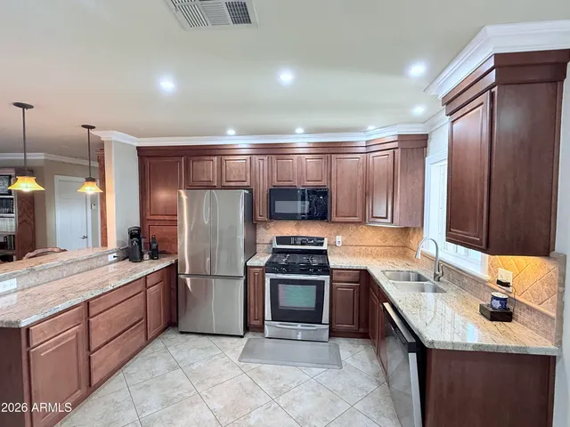 a kitchen with stainless steel appliances granite countertop a sink stove and refrigerator