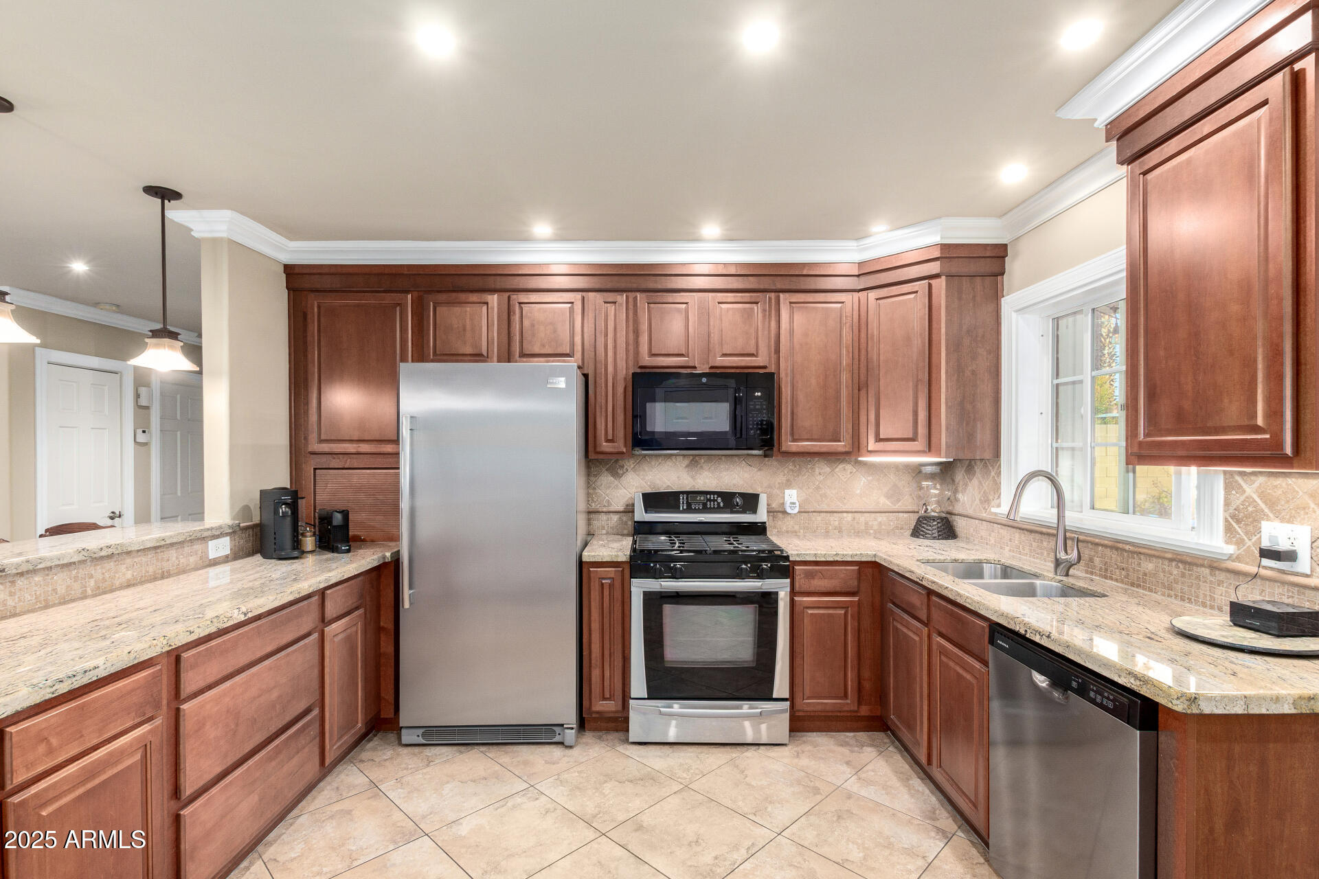 1135 East Lawrence Road Phoenix, AZ 85014 - Photo 7 of 18 a kitchen with stainless steel appliances granite countertop a sink stove and refrigerator