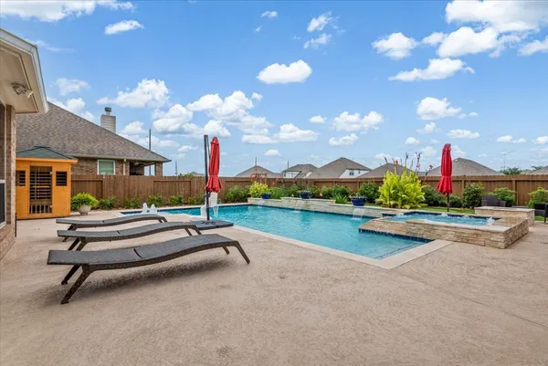 a swimming pool with outdoor seating and yard